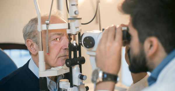 Optician looking into screening machine