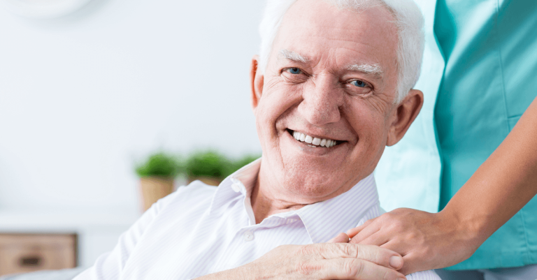 An elderly patient in a wheelchair with a health worker.