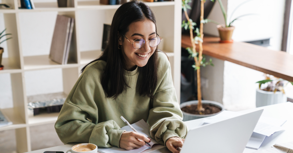 Woman smiling at desk using AI & Insight to better manage her housing stock.