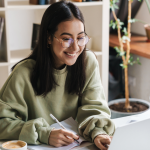 Woman smiling at desk using AI & Insight to better manage her housing stock.
